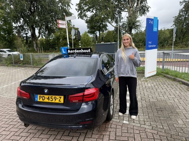 IMG_1026 Een trotse leerling staat naast de lesauto na het behalen van het rijbewijs